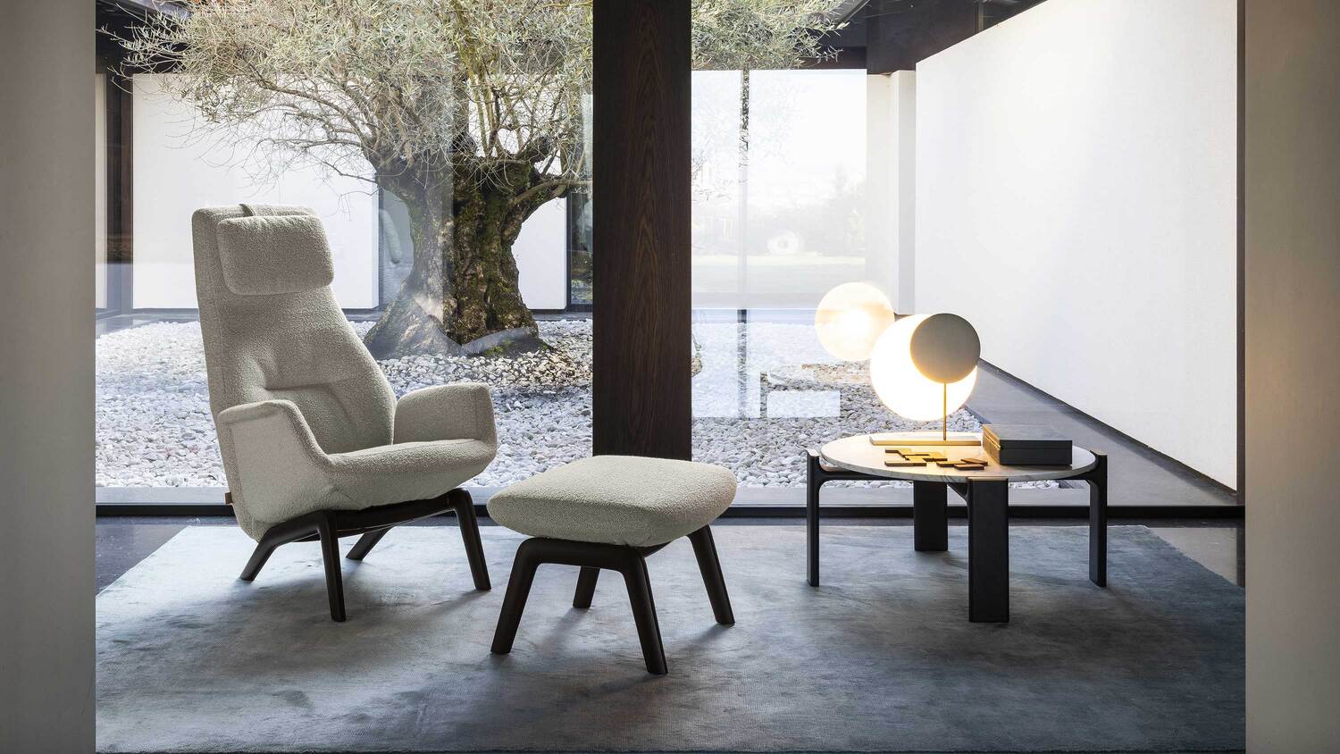 Moonbeam在室內展示的模樣，在室內落地窗邊有一張單椅以及咖啡桌，燈具放在桌上