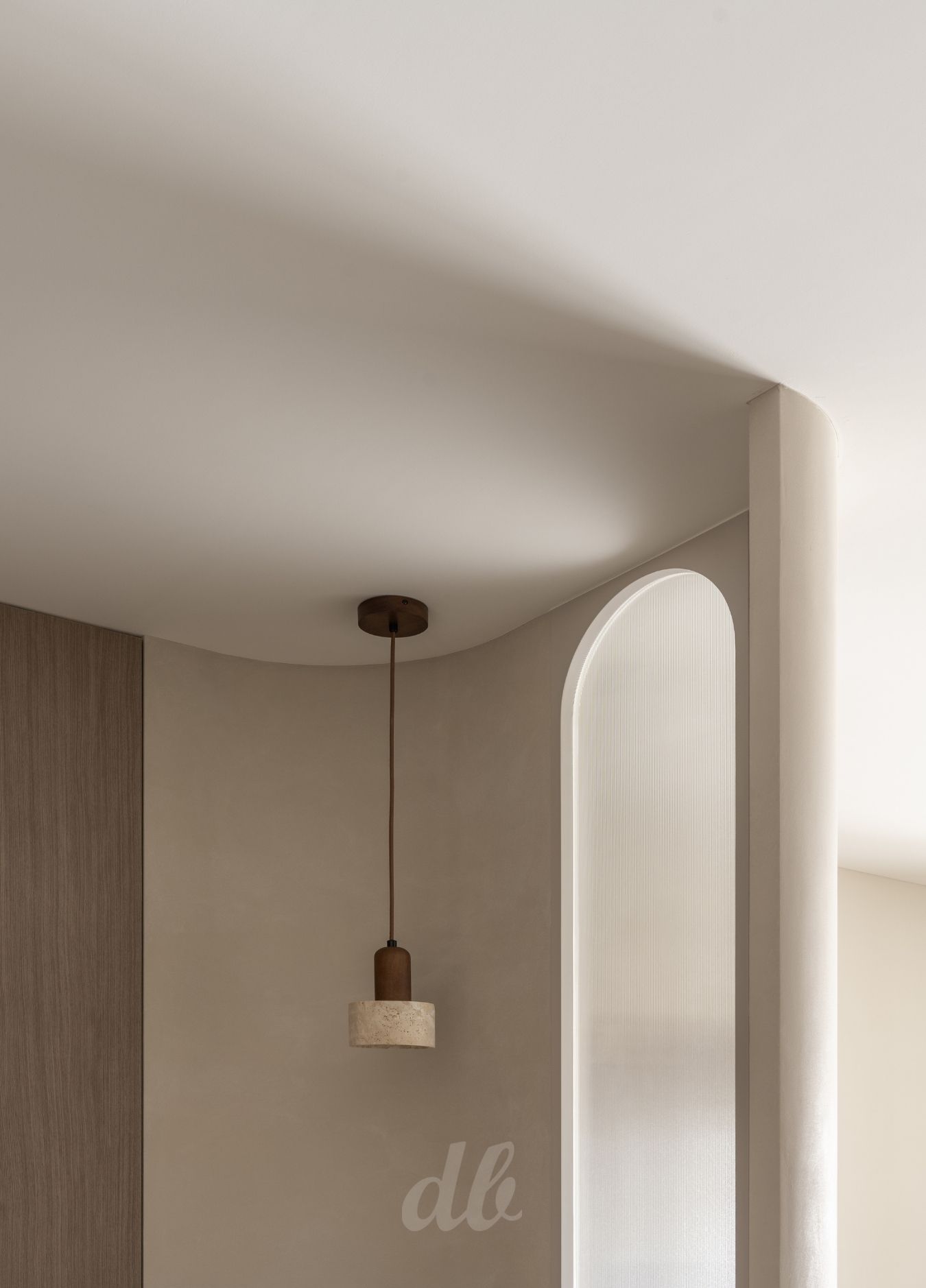 韓式奶油風美學：運用大面積的圓潤弧形天花板消弭樑柱銳利感，搭配暖米色調啞光牆面與小冰柱玻璃拱門隔屏，在洞石吊燈的點綴下，營造出具備流動感與優雅生活溫度的居家氛圍。