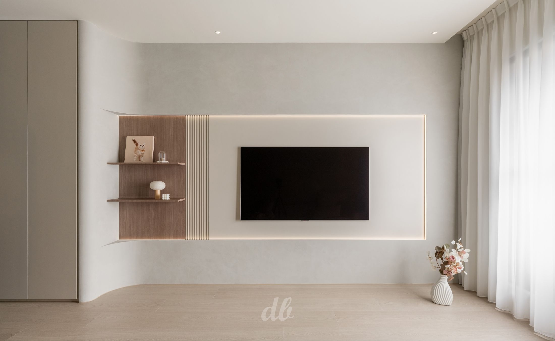 韓式奶油風電視牆日造設計案例：運用大面積弧形轉角消弭樑柱壓迫感，嵌入木質層板與格柵裝飾，並搭配線燈與溫潤米色調牆面，營造出具備流暢線條與留白美學的現代感客廳端景。