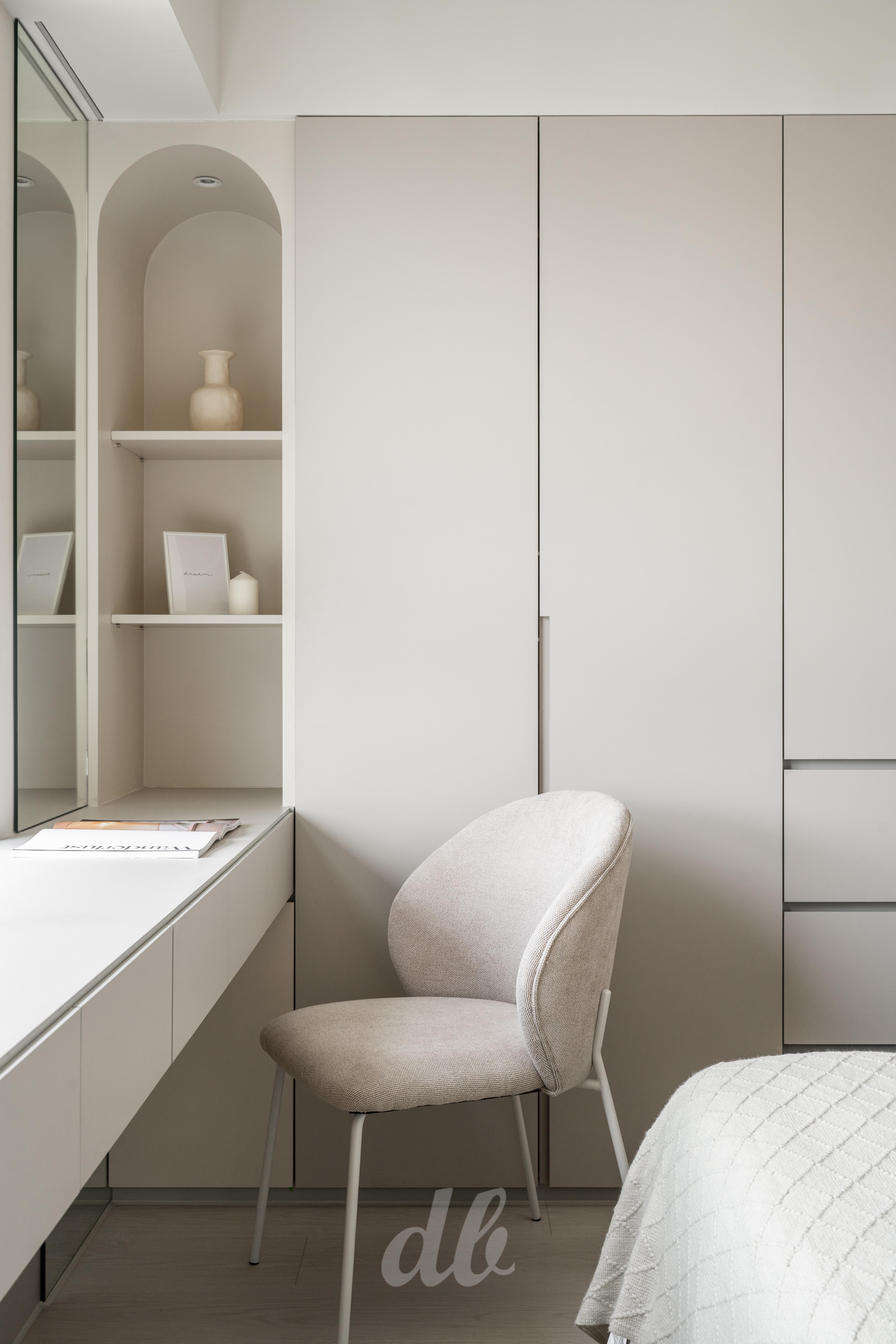 韓式奶油風臥室化妝台（日造設計案例）：採用高明度暖色調櫃體牆，嵌入精緻的圓弧造型壁龕層架，搭配線條圓潤的布藝單椅與極簡鏡面，在純粹的留白中透過弧形語彙營造出溫潤且具儀式感的私領域角落。