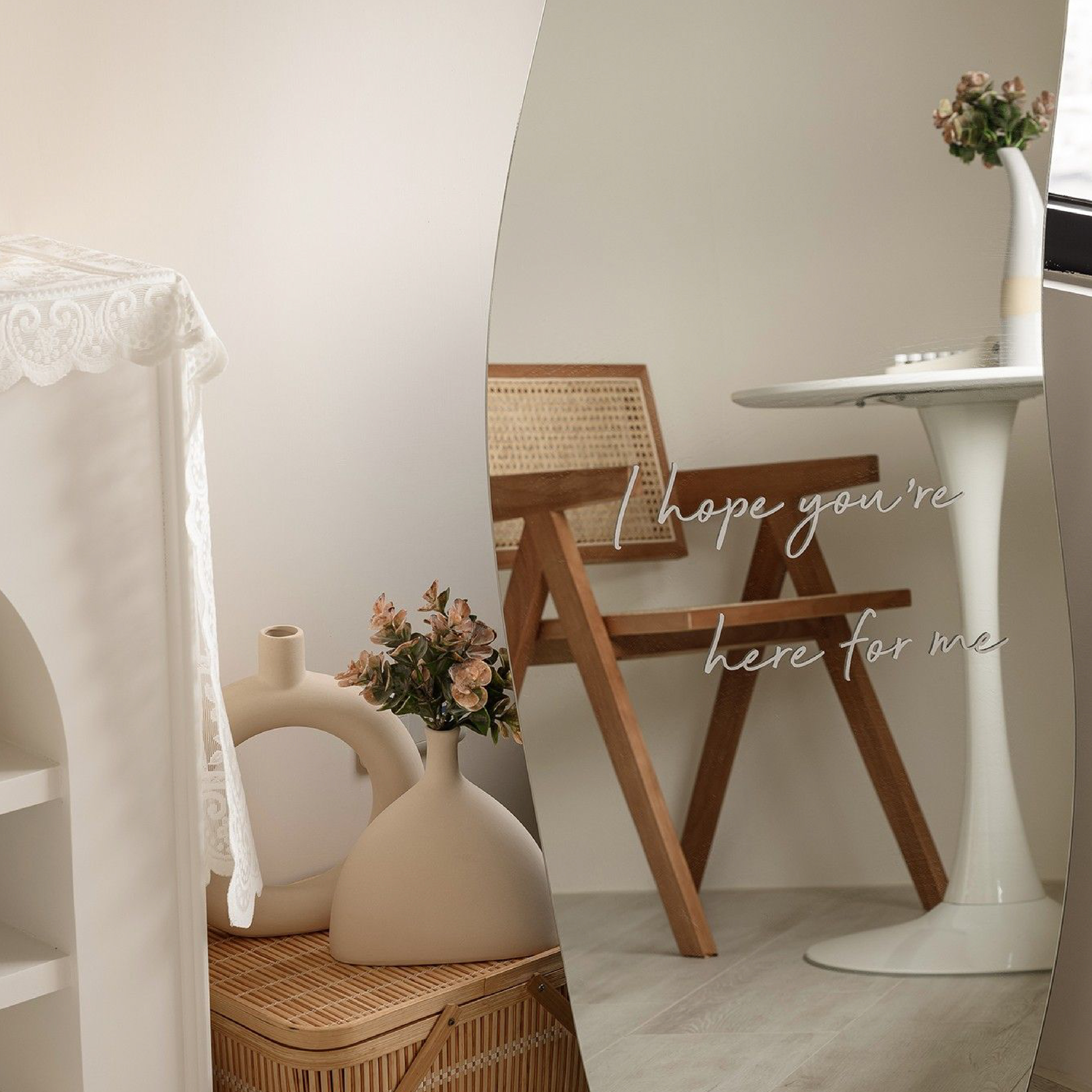 韓式奶油風居家端景：透過造型大全身鏡的映射，呈現藤編單椅、圓潤白桌與暖米色調空間的虛實交錯，搭配陶瓷藝術花瓶與藤編收納盒等自然材質軟裝，在簡約留白中勾勒出具備生活儀式感且溫潤的韓系美學角落。