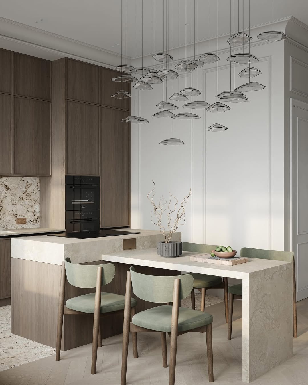 淺色大理石紋中島與 L 型同材質餐桌一體化設計，搭配鼠尾草綠絨布餐椅與壯觀的群落式藝術玻璃吊燈，在深木色壁櫃與優雅線板牆面的襯托下，營造出極具層次感與奢華藝術氣息的用餐空間。